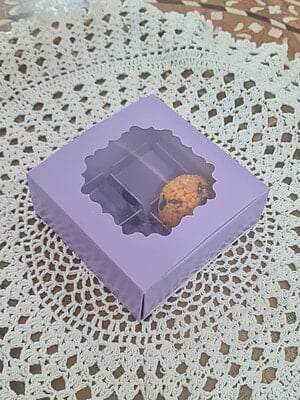Closed lavender 4-cavity box with window on lace mat